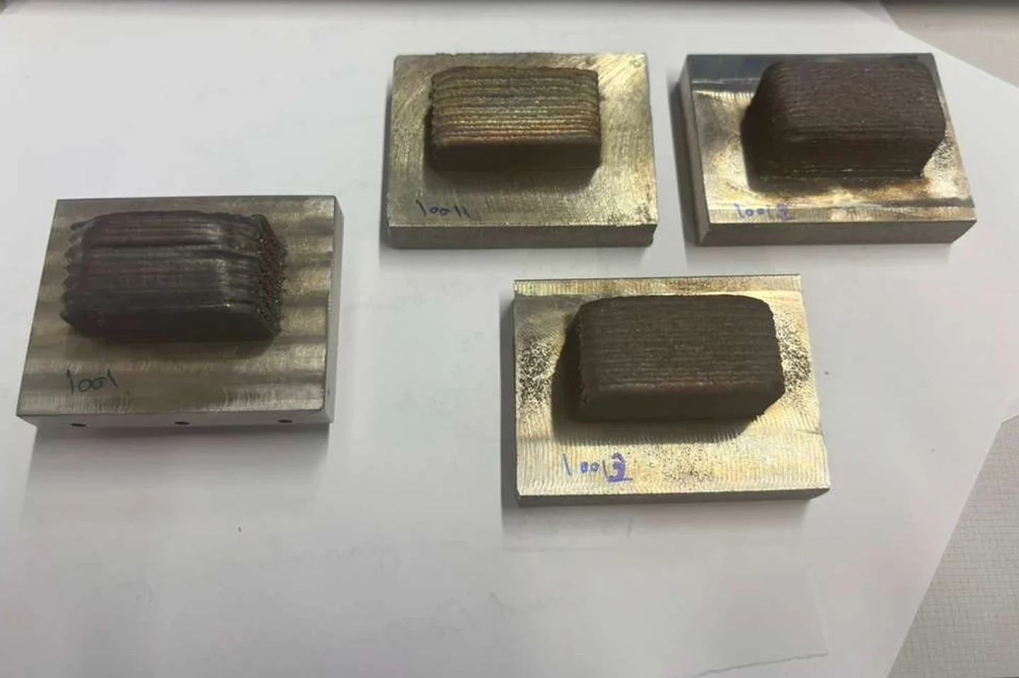Four DED metal samples on rectangular substrates