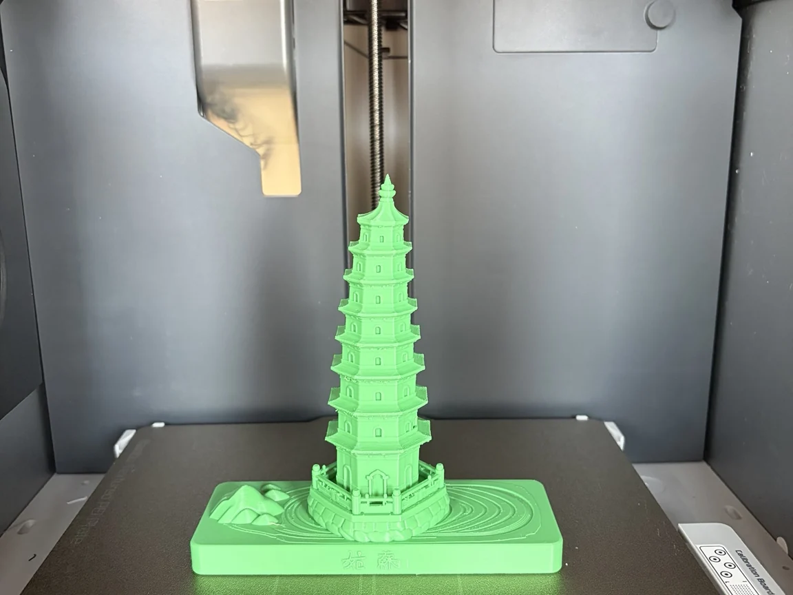 Green FDM model of Tiger Hill Pagoda, Suzhou, inside a desktop printer